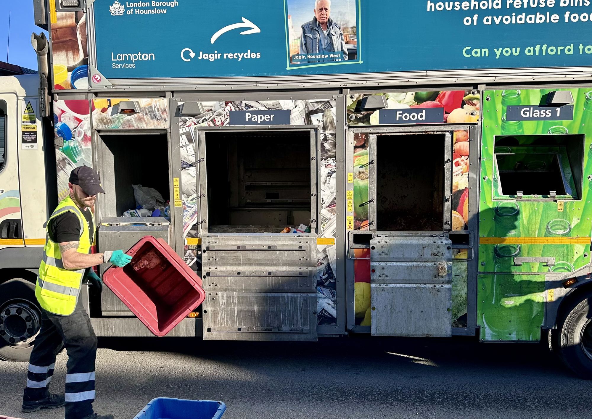A Lampton Recycle 360 crew member tipping a food caddy into a collection lorry, with a Hounslow resident pictured on its side